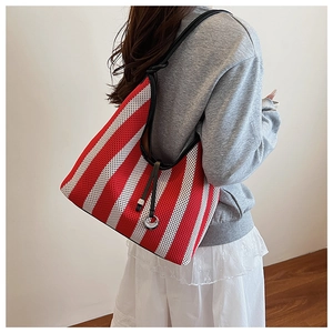 Detail of red and white striped tote with mesh texture and black leather knotted strap
