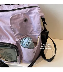 Detail of front snap pocket on lavender outdoor bag storing a blue folding umbrella