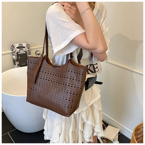 Détail du sac cabas marron foncé avec motifs géométriques découpés au laser et anses fines