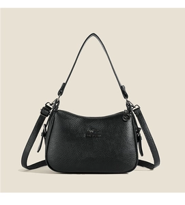 Detail view of black litchi grain leather shoulder bag with metallic kangaroo logo