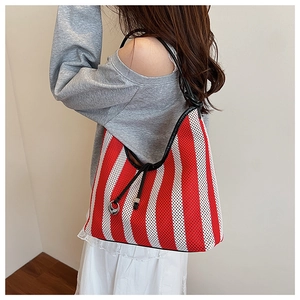 Detail of red and white striped knit tote bag with black strap and drawstring closure