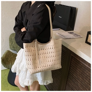 Détails de motifs ajourés au laser sur un grand sac cabas beige élégant d'été