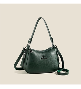 Detail of dark green pebble leather handbag with embossed kangaroo logo and hardware