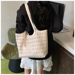 Détail du motif ajouré géométrique découpé au laser sur le grand sac cabas blanc crème