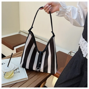 Detailed shot of striped mesh tote bag with leather trim and silver metal buckle detail