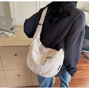 Beige large capacity crossbody bag showing nylon texture and braided zipper pulls