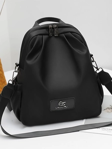 Zaino minimalista in nylon nero con manico superiore e spallacci regolabili su pedana