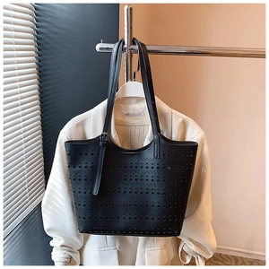 Vue détaillée du motif géométrique découpé au laser sur le sac cabas noir en similicuir