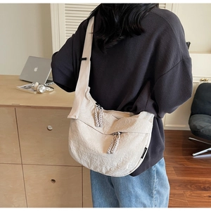 Detail of beige pleated nylon crossbody bag with thick woven rope zipper pull texture