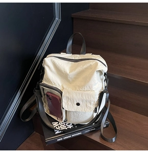 Detail of cream nylon bag featuring transparent phone pocket and urban techwear straps