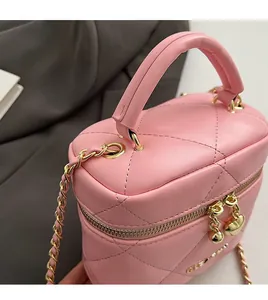 Dettaglio mini borsa a secchiello trapuntata rosa con cuore dorato e tracolla a catena