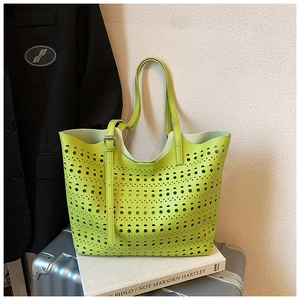 Détail du sac cabas vert avec motifs géométriques ajourés et bandoulière réglable en métal
