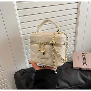 Dettaglio della mini borsa a secchiello trapuntata beige con catena dorata