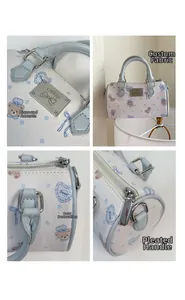 Detail of Boston bag showing mini crystal bow, printed bear, and ruffed blue handle