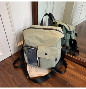 Detail of nylon travel bag featuring a transparent phone pocket and premium texture