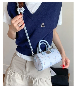 Detail of light blue Boston bag featuring cute cartoon bear print and adjustable strap
