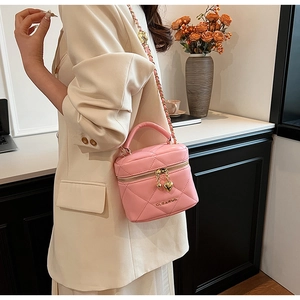 Dettaglio mini borsa a secchiello trapuntata rosa con ciondolo a cuore e catenella