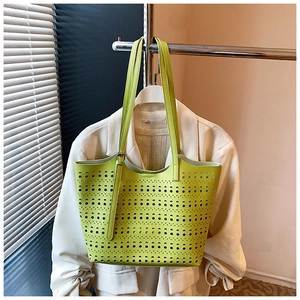 Vue détaillée du sac cabas jaune fluo ajouré au laser avec bandoulières en cuir assorties