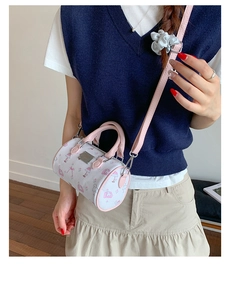 Detail of mini barrel crossbody bag with pink cartoon prints and adjustable strap