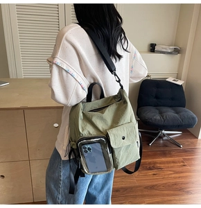 Detail of light green backpack with clear PVC phone pocket and rainbow trim strap