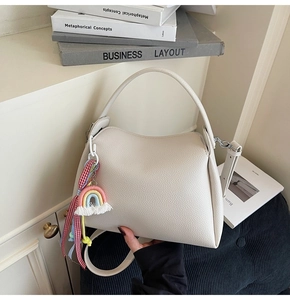Détail du sac seau en cuir grainé blanc cassé avec pendentif arc-en-ciel coloré