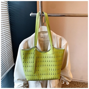 Détails macro des motifs géométriques découpés au laser sur le sac cabas vert fluo