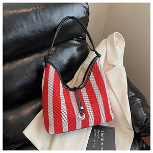 Detail of red and white striped knit tote bag with black leather straps and silver ring