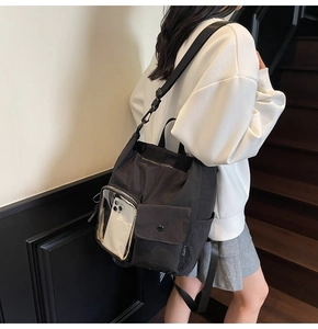 Detail of black tactical backpack with transparent phone window and buckle pocket on stairs