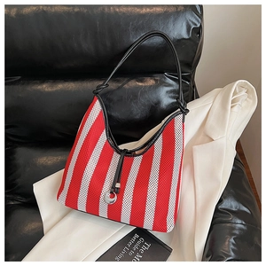Detail of red and white striped mesh tote bag with silver crescent charm and black strap
