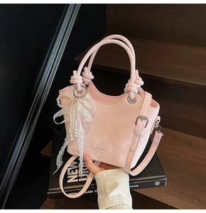 Sac seau en cuir mat rose avec breloques élégantes en perles et nœud en dentelle