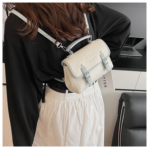 Close-up of retro cream crossbody bag with light blue trim and PAN 'TOR embossed logo