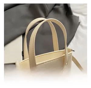 Détail de la poignée en similicuir et des boucles métalliques du sac seau crème