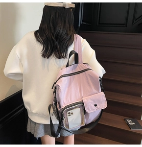 Detail view of a lavender nylon backpack featuring a transparent PVC front utility pocket