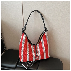 Detail of red and white striped knit tote bag with black leather handle and metal ring buckle