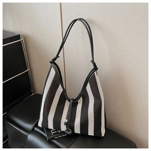 Detail of striped mesh tote bag featuring leather drawstring and logo pendant decoration