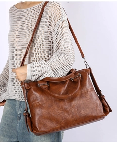 Brown faux leather tote bag being worn on the shoulder for a modern commute style