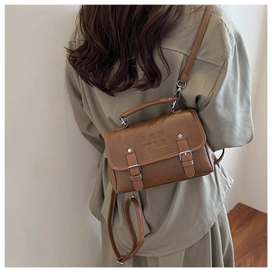 Detail of dark brown retro leather crossbody bag with silver buckles and PANTOR logo