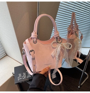 Sac seau rose en faux daim avec charm nœud en perle et dentelle et détail de poignée