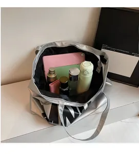 Interior view of large silver tote bag showing spacious capacity with tablet and daily items