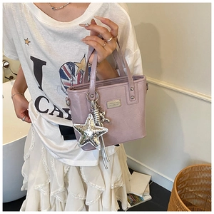 Detail of lavender croc-effect mini tote bag with star charm and silver balloon dog pendant