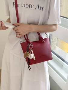 Minimalist red leather bucket handbag for women with creative baseball theme charm accessory