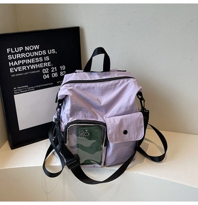Detail of purple nylon travel backpack featuring a transparent PVC phone pocket and strap