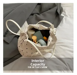 Détails de la capacité interne du sac fourre-tout matelassé blanc à motifs nœuds noirs