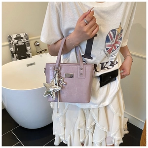 Detail of purple crocodile pattern bucket bag with star and bear silver charms