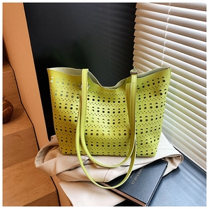 Gros plan des motifs géométriques découpés au laser sur le sac cabas vert vif