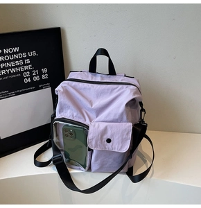 Detail of lavender nylon travel bag featuring a transparent front window for smartphone storage