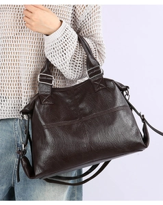 Deep brown faux leather tote bag with cross stitching detail shown on model side view