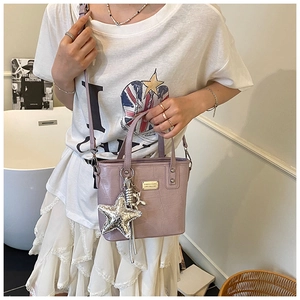 Detail of light purple crocodile pattern bucket bag with star and balloon dog charms