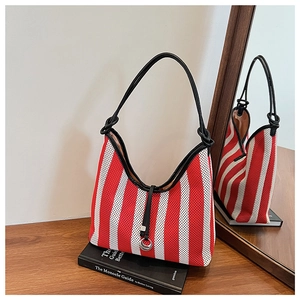 Detail shot of the red and white striped knit hobo bag with a black leather shoulder strap