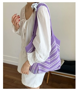 Dettaglio della borsa tote in maglia a righe viola e bianche con trama di tessuto all'uncinetto